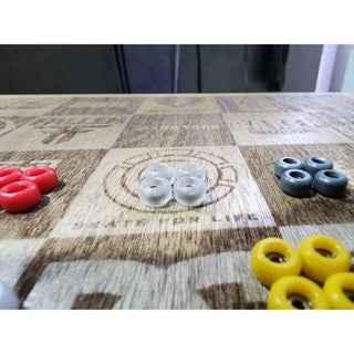 Assorted colorful mini fingerboard wheels on a custom wooden deck surface.