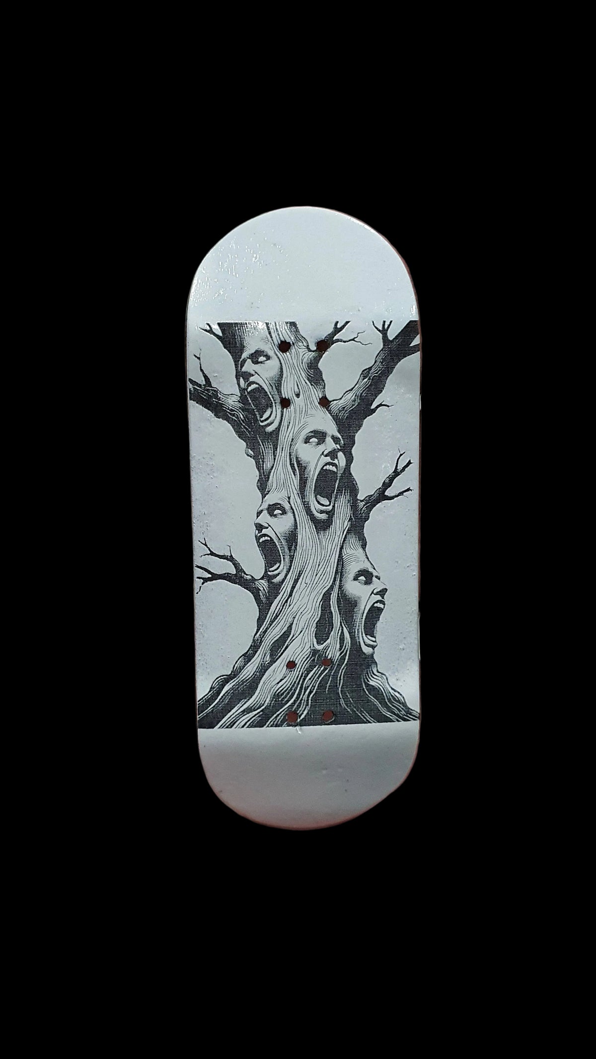 Skateboard deck with tree-screaming face artwork on light-colored grip surface