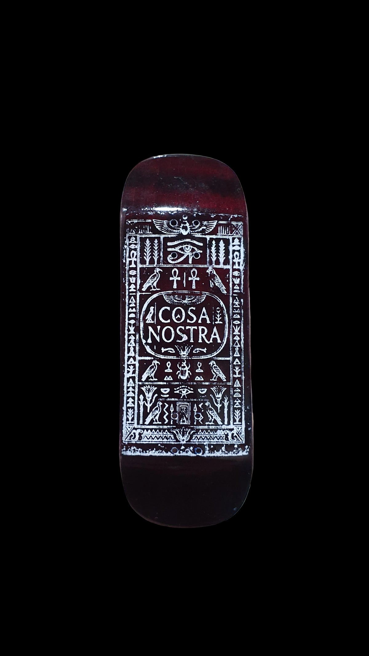 Cosa Nostra fingerboard deck with white ornate lettering and graphic on a dark red-brown surface
