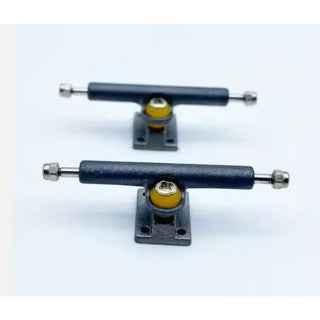 Two sets of professional fingerboard trucks with yellow bushings on a white background