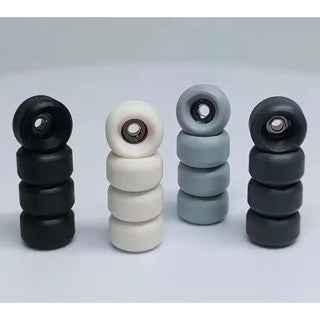 Four stacks of miniature fingerboard wheels in black, white, and grey colors.