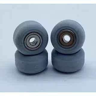 Pair of grey miniature fingerboard wheels with metal bearings.