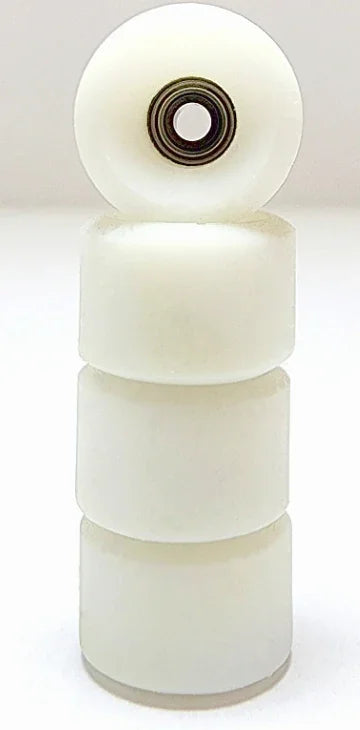 Stack of white miniature fingerboard wheels with one wheel showing the metal bearing.