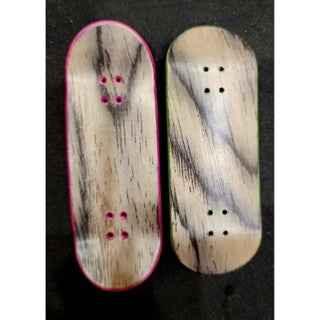 Two handmade custom fingerboard decks with natural wood grain finish.