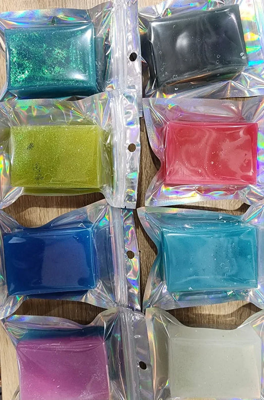 Assorted colorful fingerboard wax bars in iridescent individual packaging.