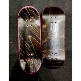 Two handmade custom wooden fingerboard decks with dark wood grain finish.