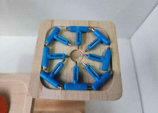 Blue T-shaped fingerboard tools arranged in a wooden storage box