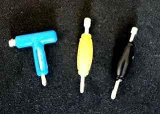 Three colorful fingerboard accessories in blue, yellow, and black on a dark background