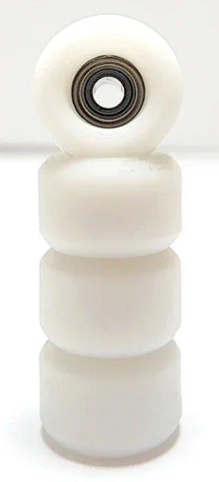 Stack of four white miniature fingerboard wheels with a metal bearing.