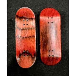 Two handmade wooden fingerboard decks with a reddish natural wood grain finish.