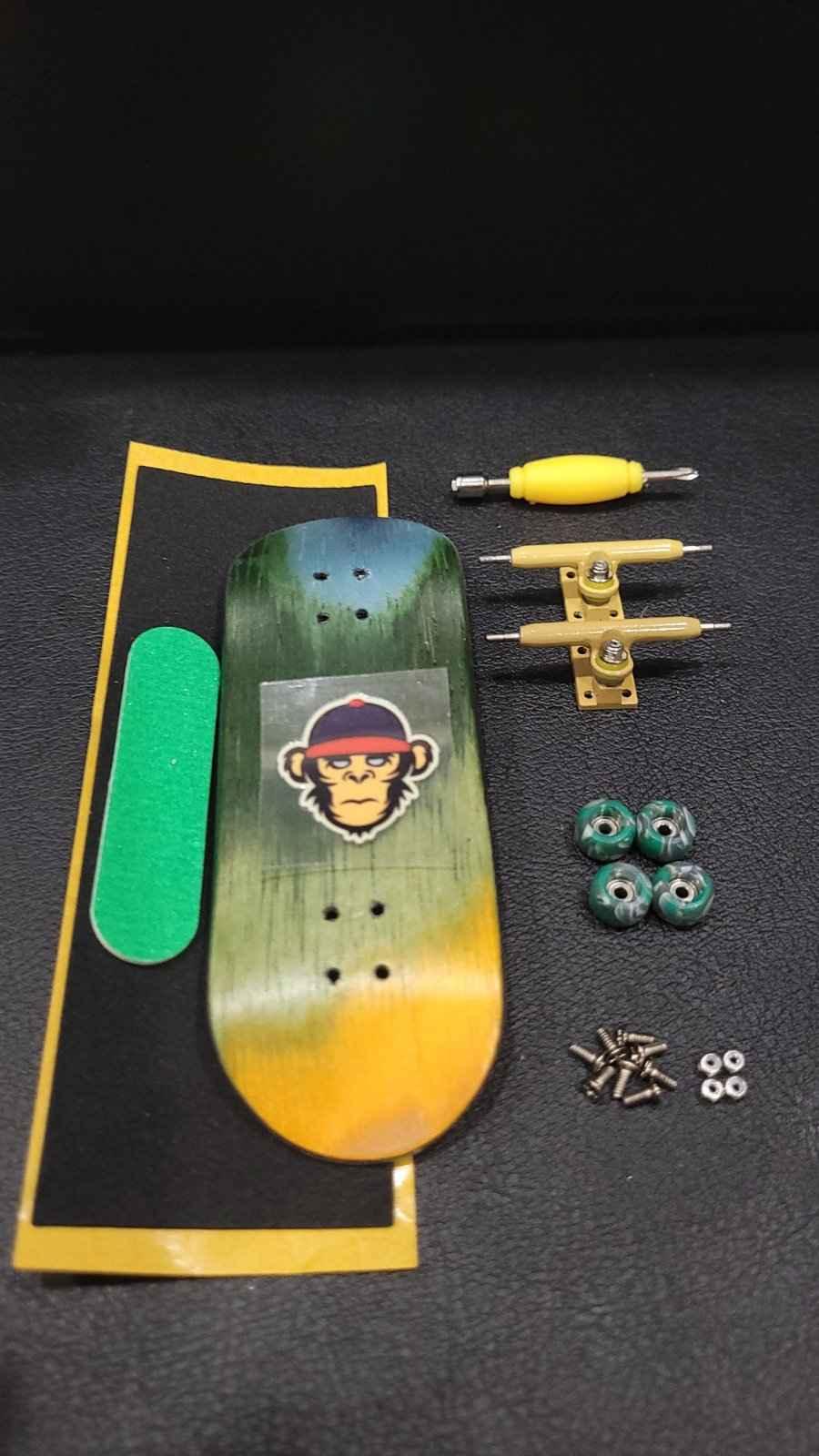 Custom fingerboard kit with a monkey graphic deck, yellow trucks, and green wheels.