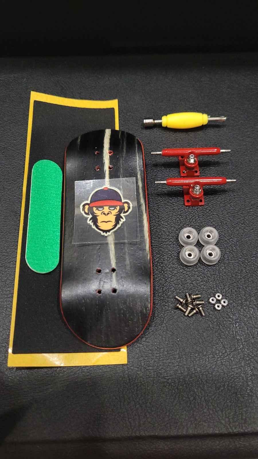 Custom fingerboard kit with black deck, red trucks, white wheels, and green grip tape.