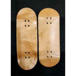 Two handmade wooden fingerboard decks with natural wood grain texture.