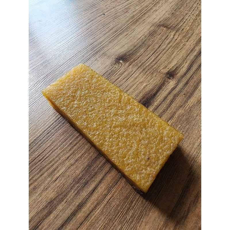 Rectangular handmade fingerboard deck with a textured wood grain finish on a wooden surface.