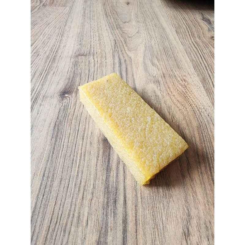 Rectangular yellow fingerboard foam block on a light wood surface