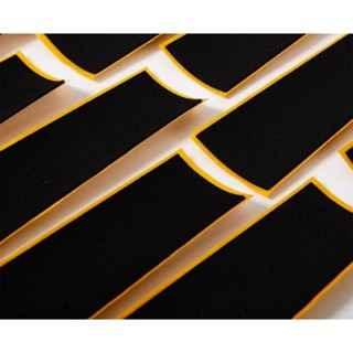 Close-up of black grip tape with a custom diagonal cut pattern on a fingerboard deck