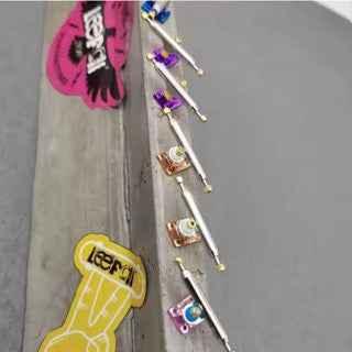Custom handmade fingerboard decks and miniature skate accessories on a concrete surface.