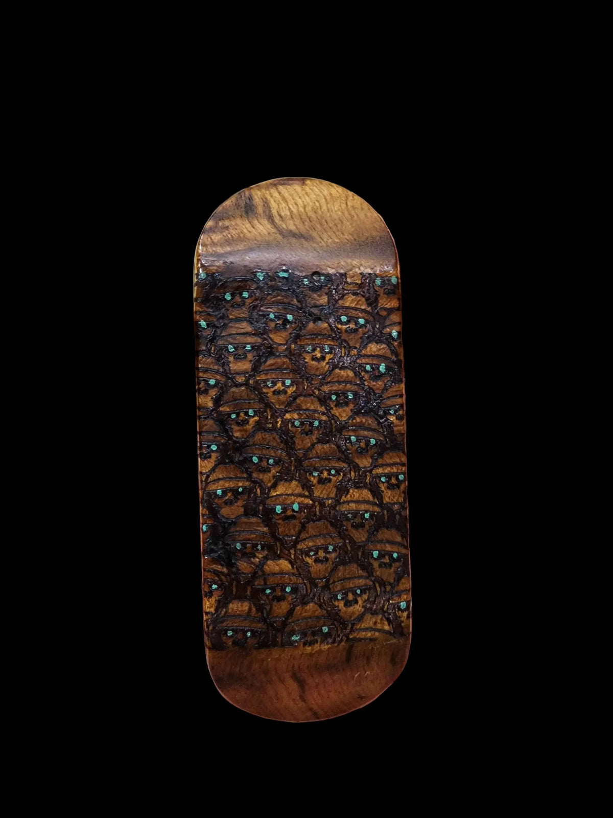 Handmade wooden fingerboard deck with intricate carved faces and turquoise inlays