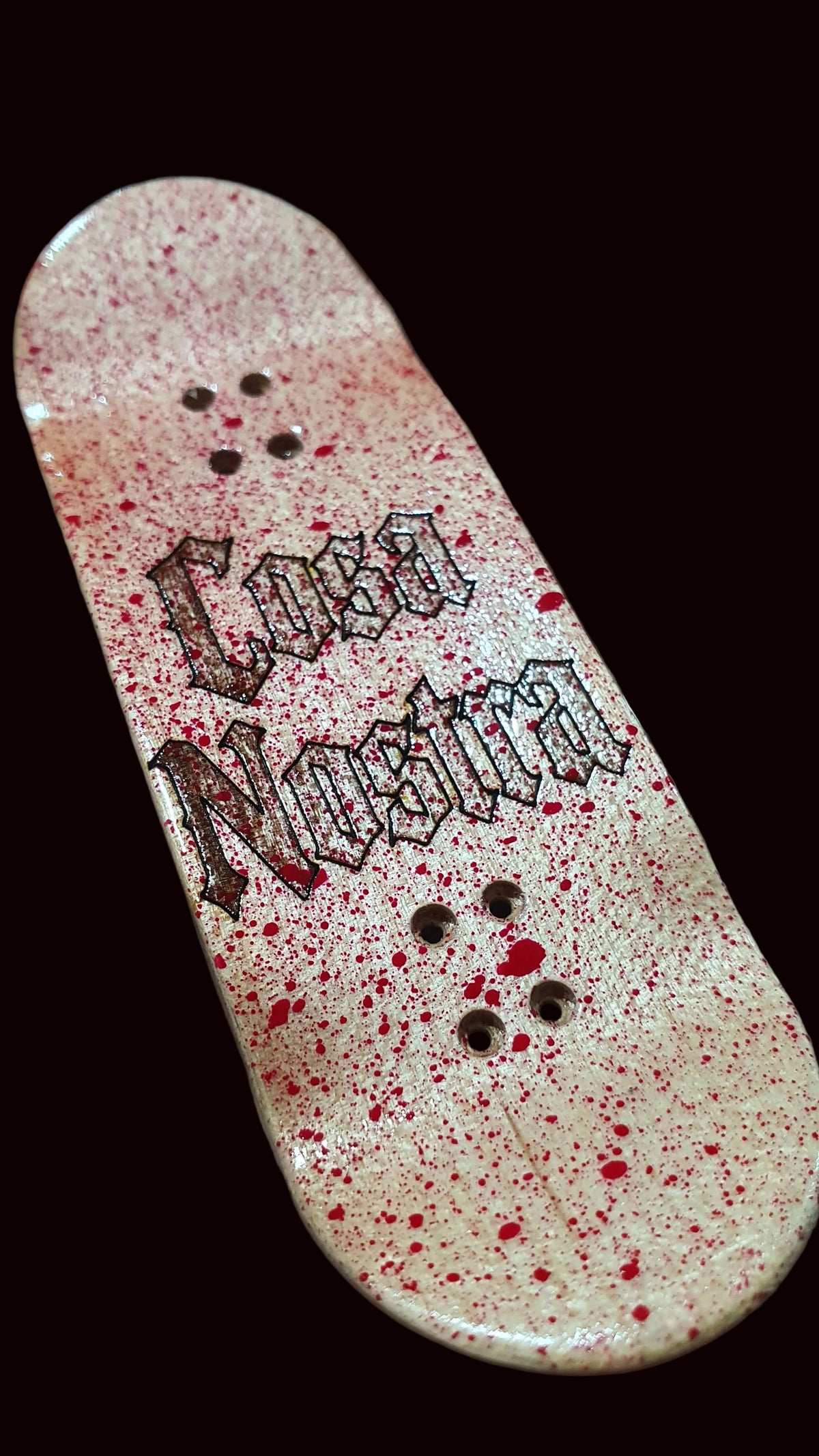 Popsicle fingerboard deck, white-pink speckled finish with black text graphic and mounting holes