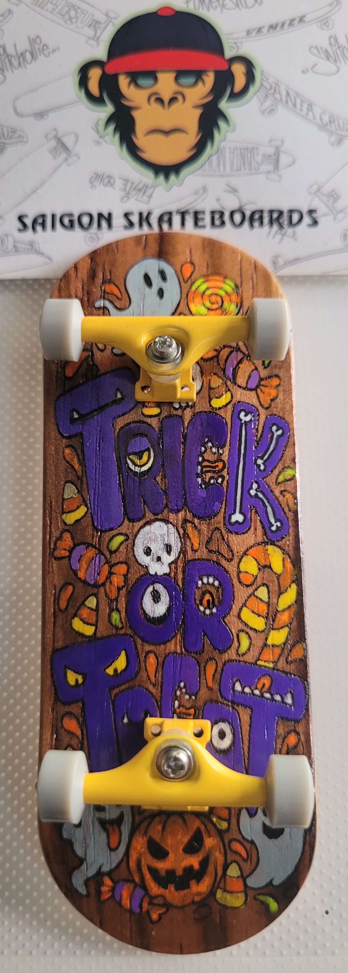 Complete skateboard with orange Halloween deck art, silver trucks, and white wheels