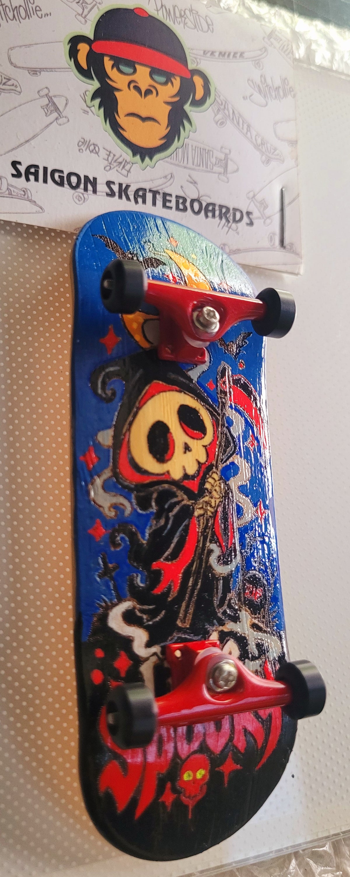 Blue fingerboard deck with skull witch artwork, black accents, and red "Little Spooky" lettering