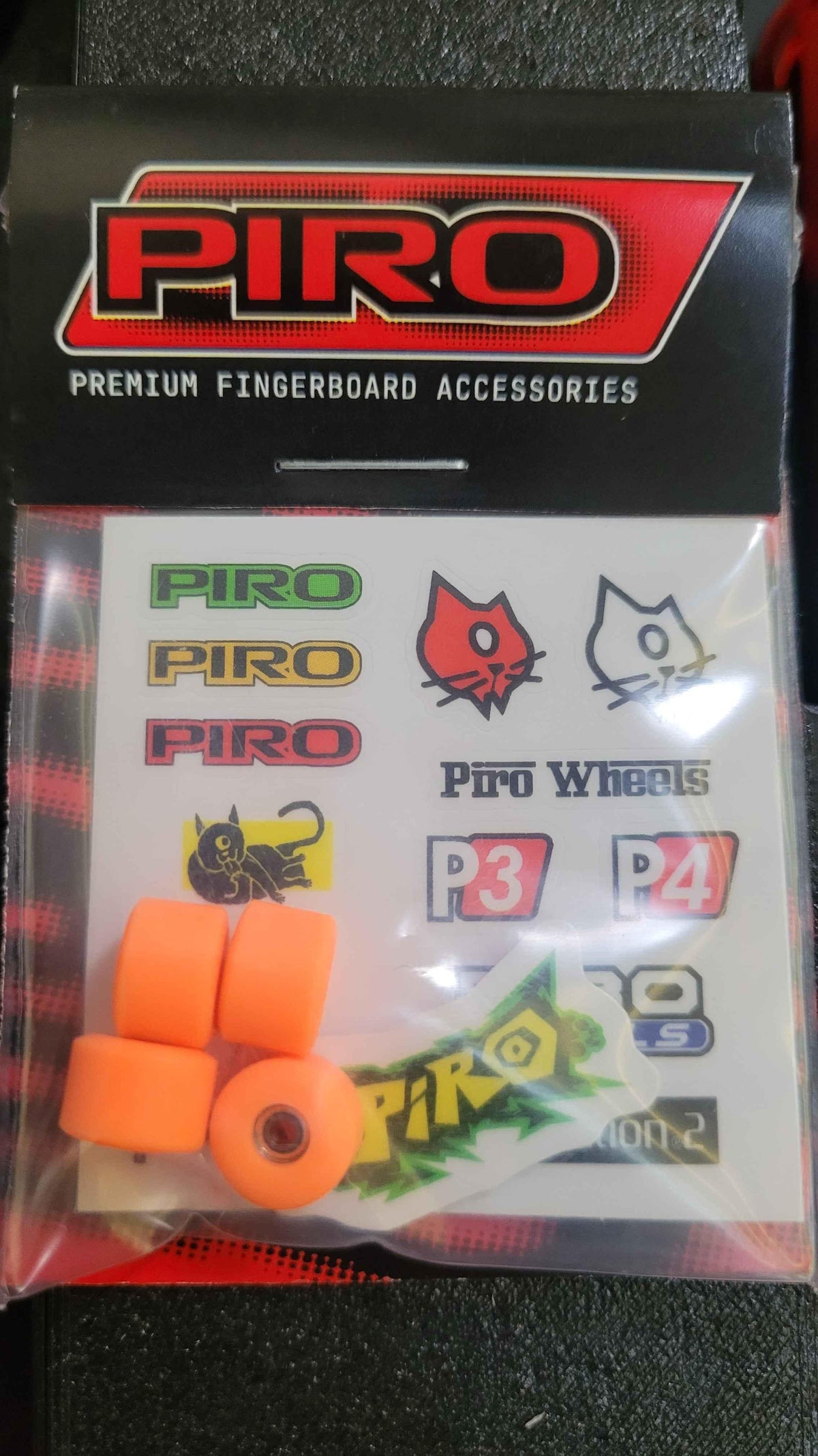 Piro premium fingerboard accessories set with orange wheels and brand stickers.