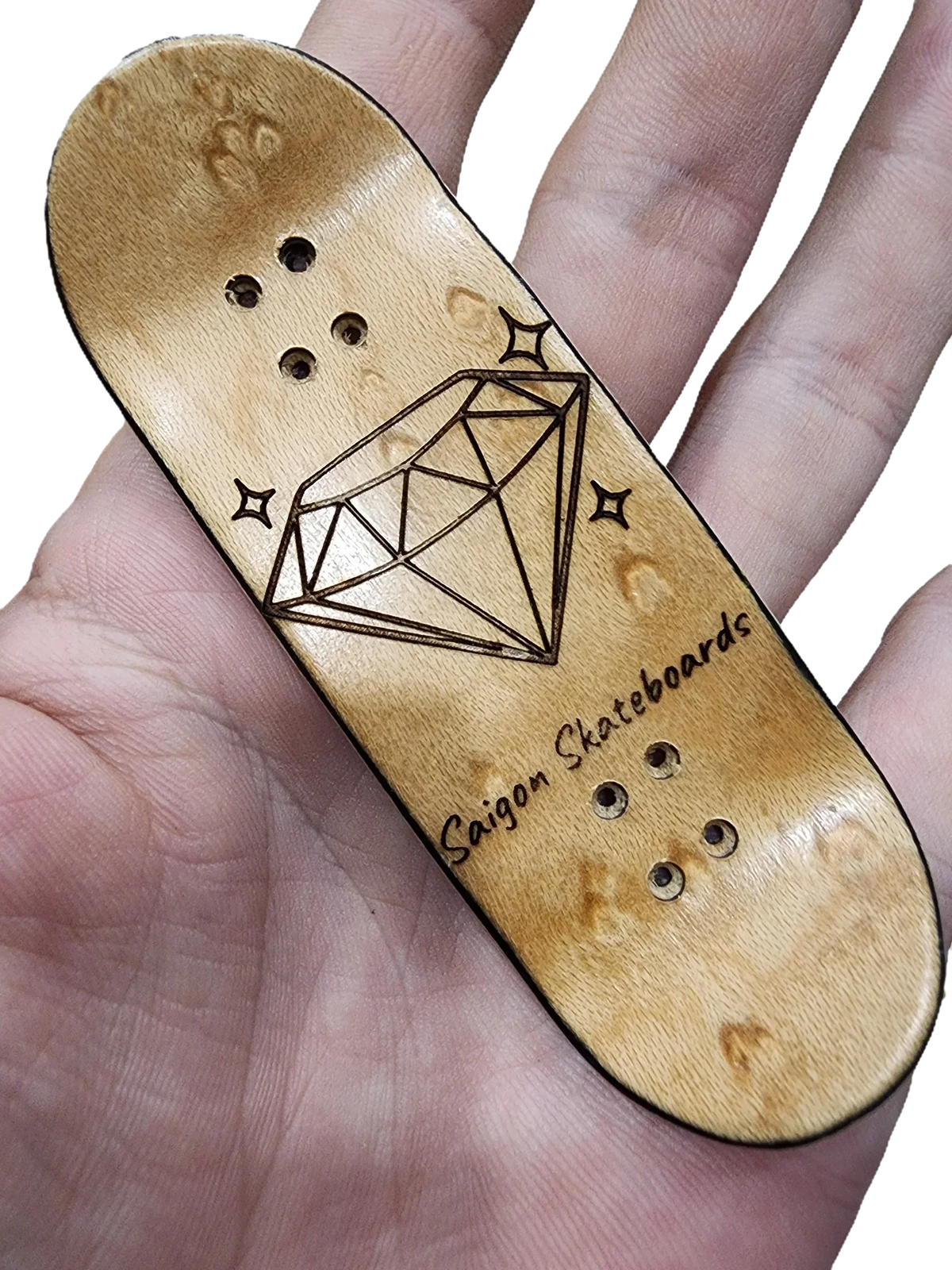 Handmade wooden fingerboard deck with a diamond engraving held in a hand