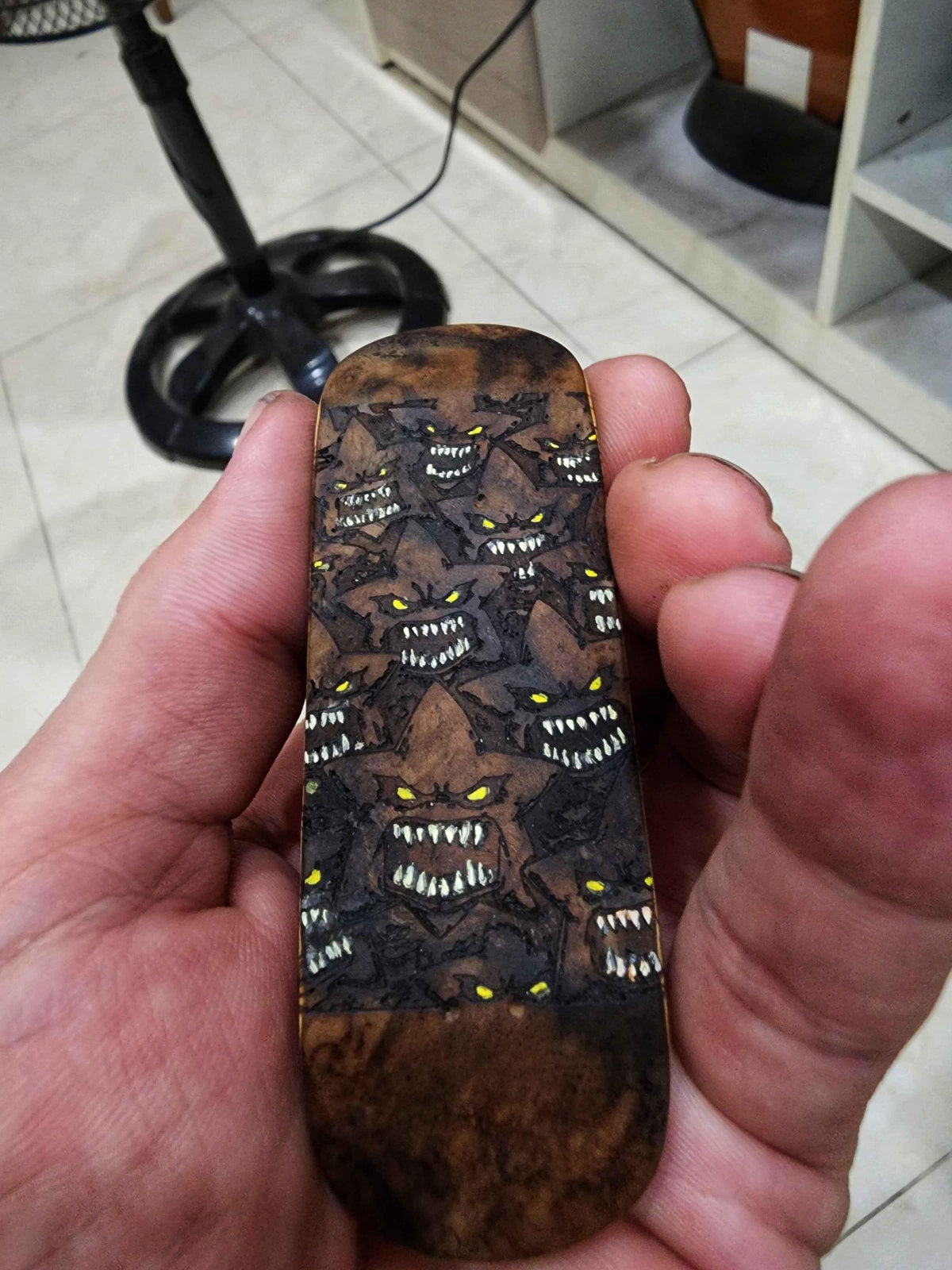 Handmade custom fingerboard deck with dark monster graphic and yellow eyes.