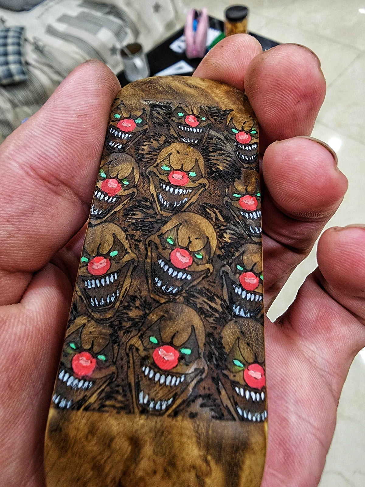 Handmade custom fingerboard deck featuring a repeating creepy clown graphic design.