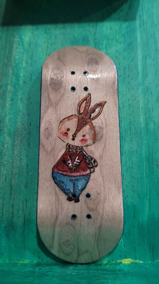 Handmade wooden fingerboard deck featuring a cute bunny illustration.