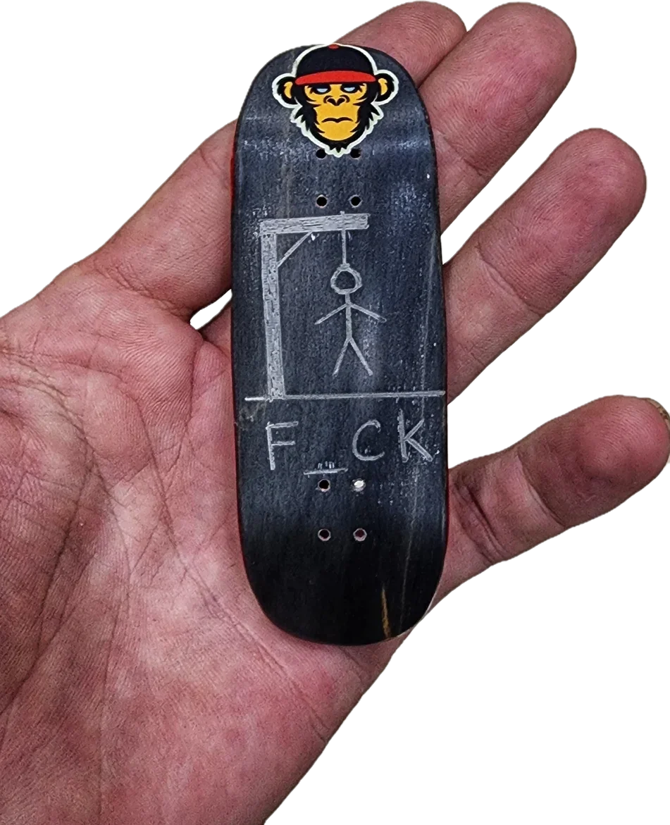 Dark fingerboard deck with cartoon face graphic and bold “F.C.K” text