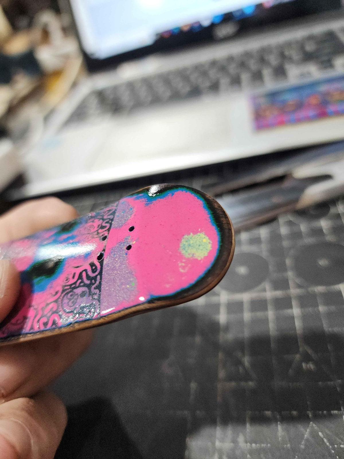 Handmade custom fingerboard deck with vibrant pink and blue graphic design.