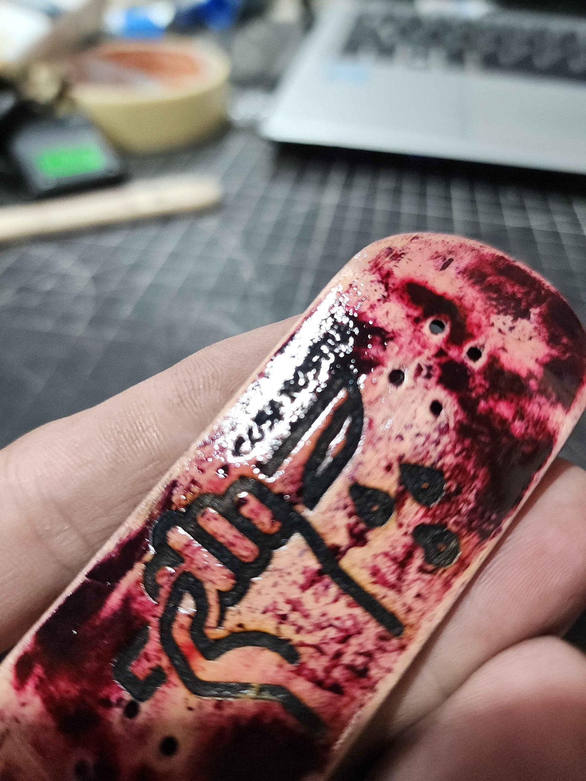 Handmade custom fingerboard deck with red splatter art and black graphics