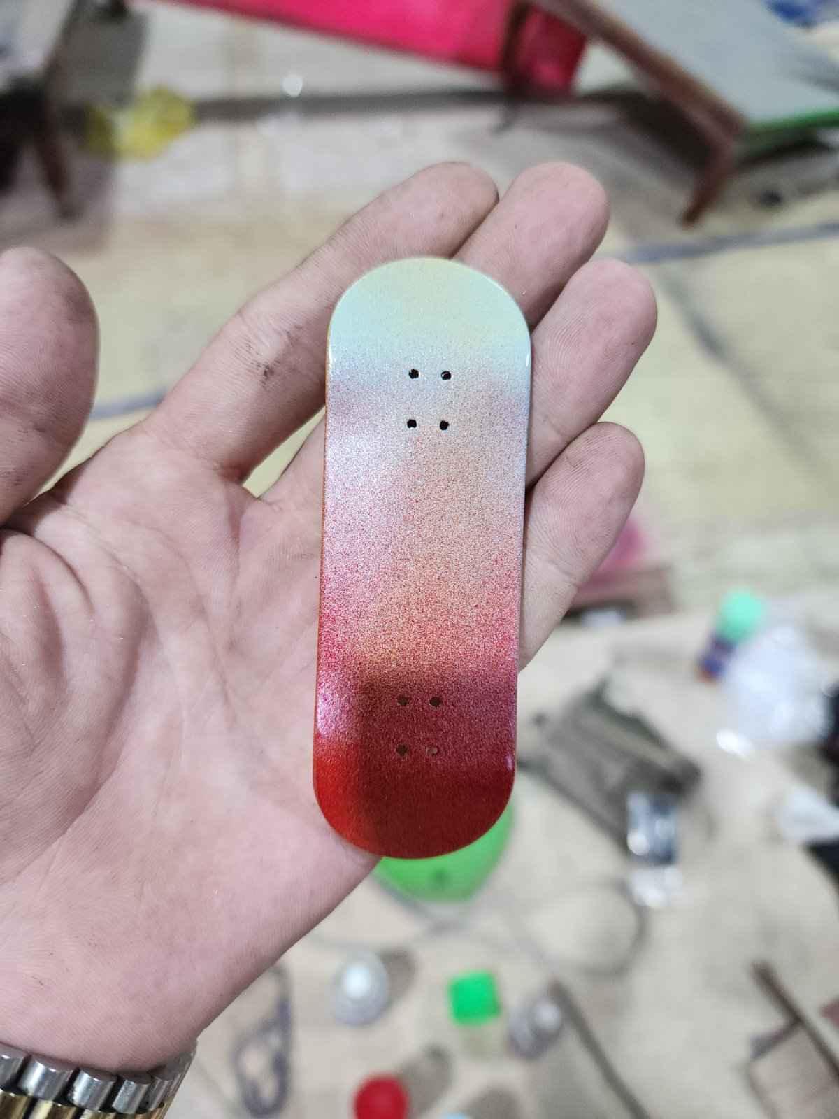 Handmade custom fingerboard deck with a red and white gradient finish.