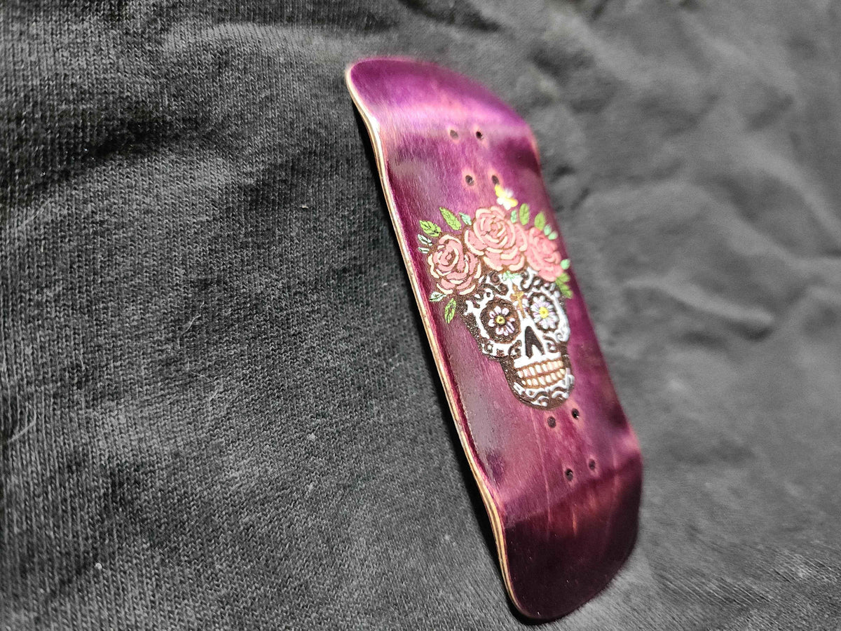 Handmade purple fingerboard deck with sugar skull and pink rose graphic design.