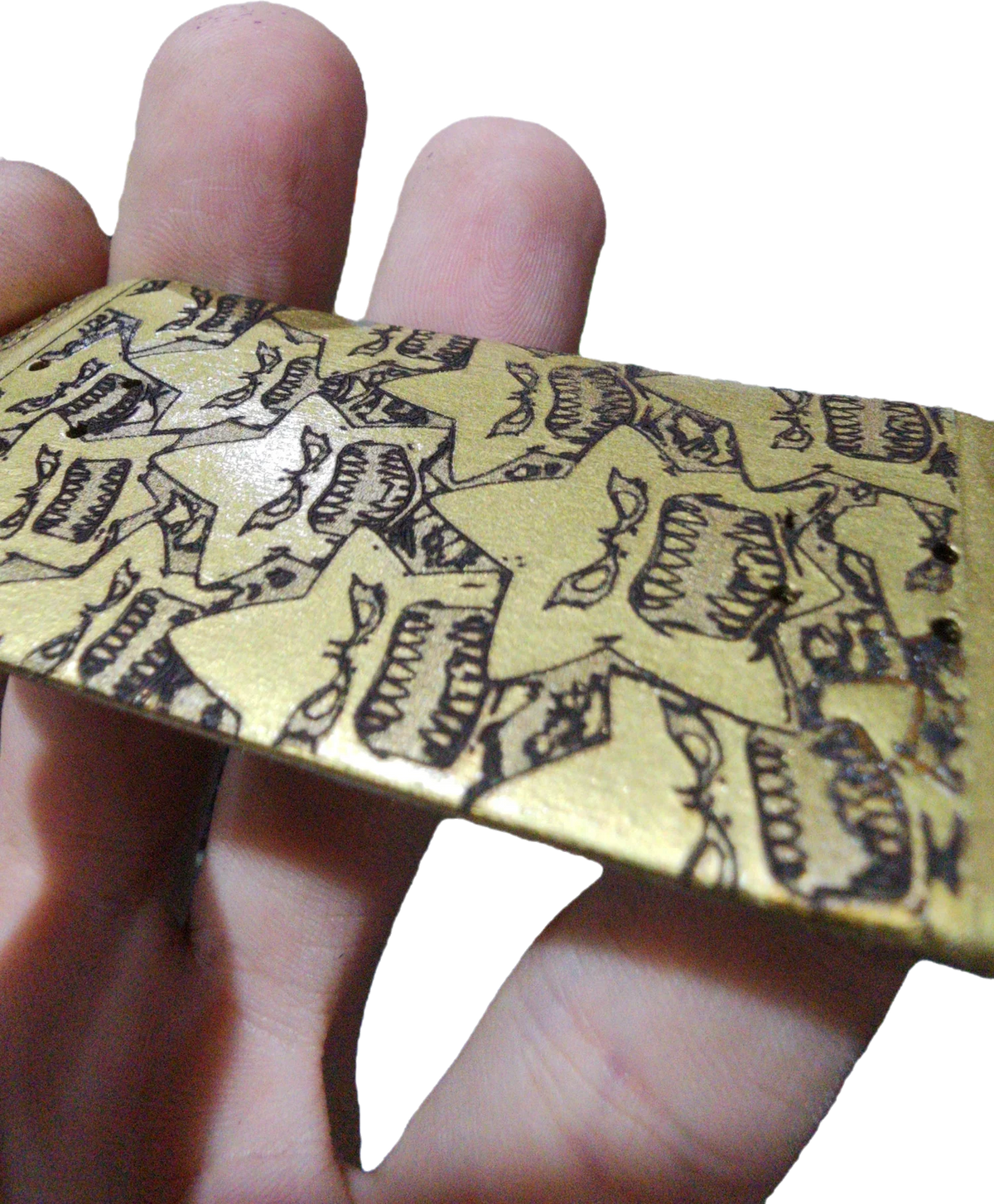 Handmade custom fingerboard deck with gold star graphic pattern held in hand.