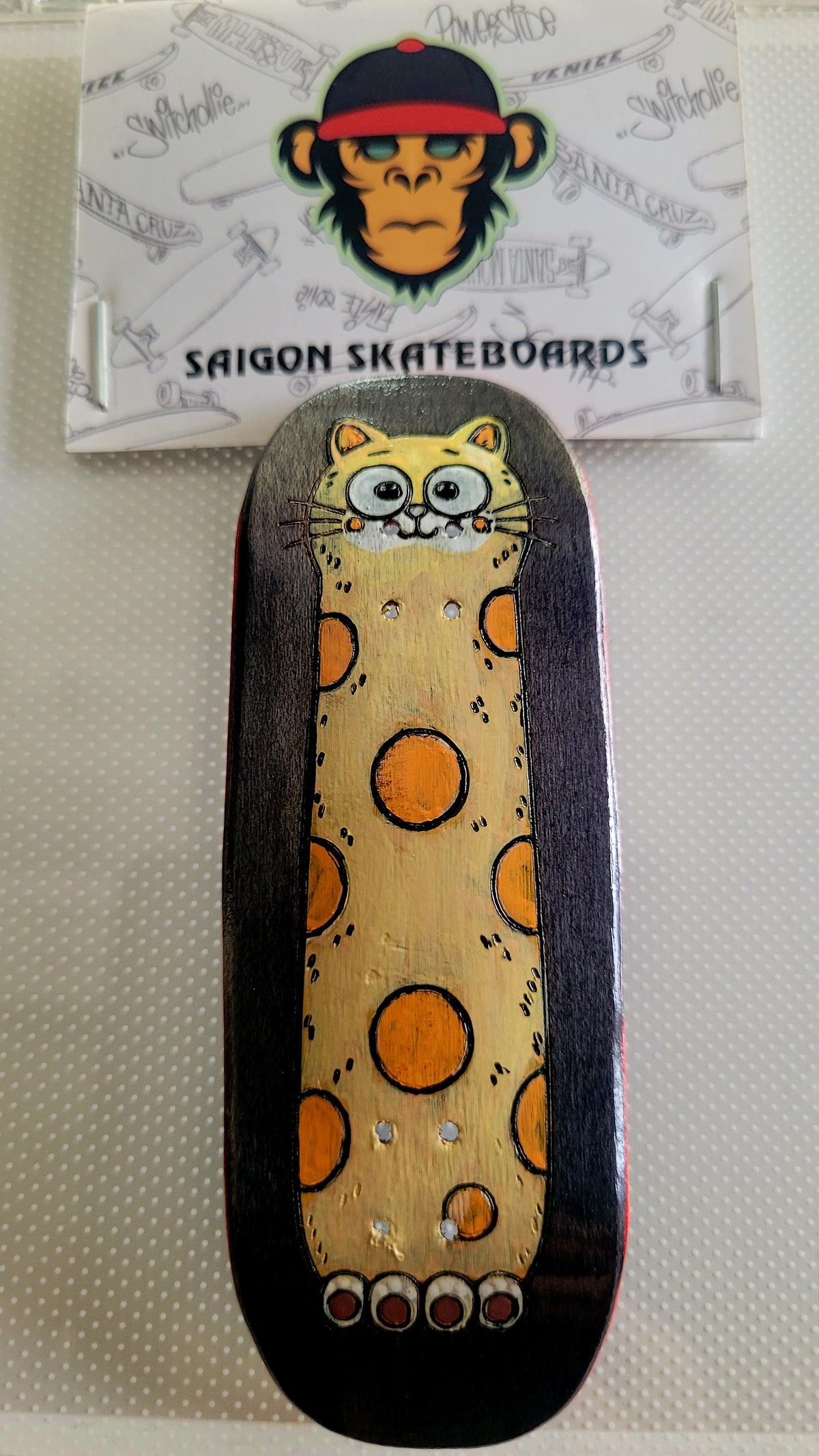 Fingerboard deck with cat graphic, dark sides, yellow speckled background