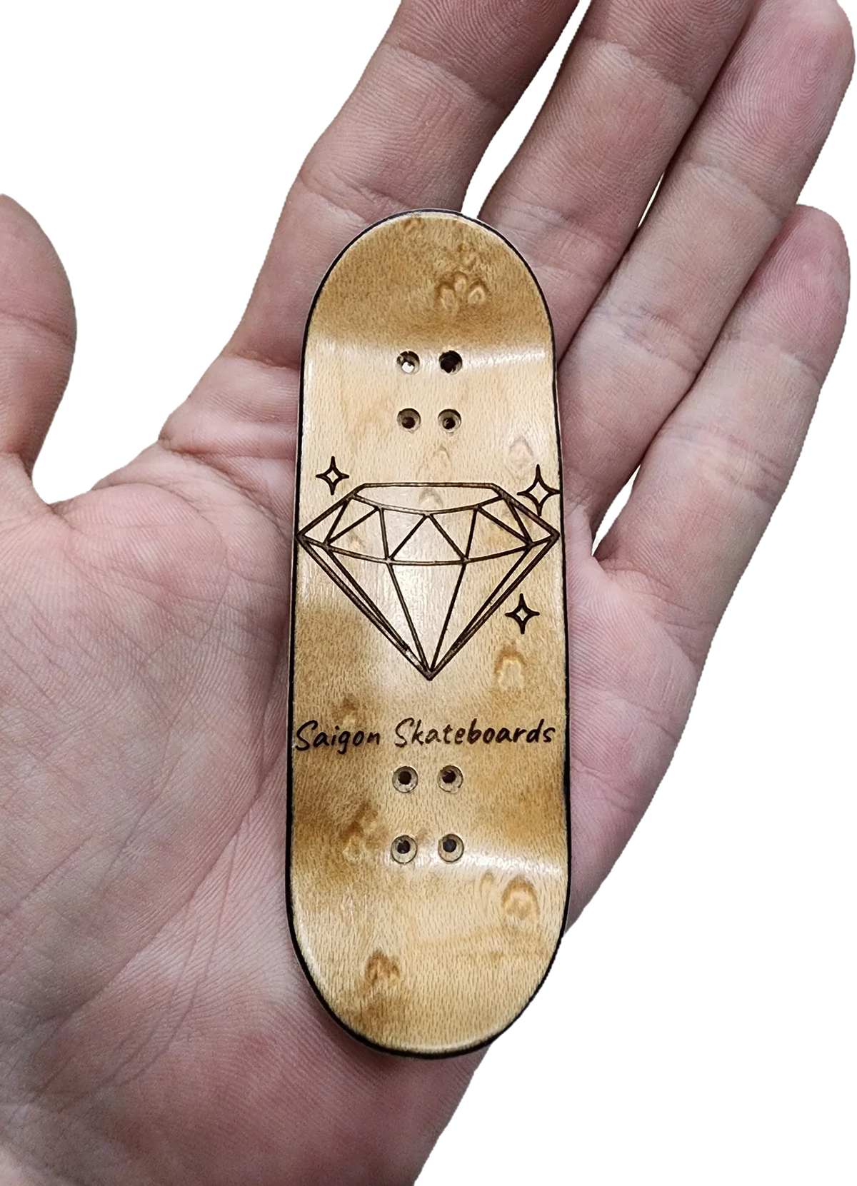Hand holding a custom wooden fingerboard deck with a diamond engraving and Saigon Skateboards text.