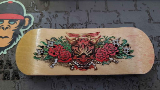 Oni Mask fingerboard deck, close-up of shuriken and rose detail