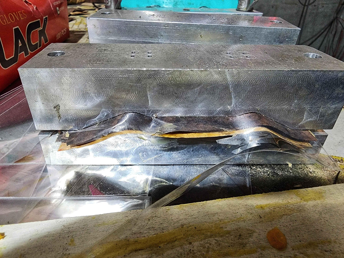 Metal press machine molding a custom handmade fingerboard deck.