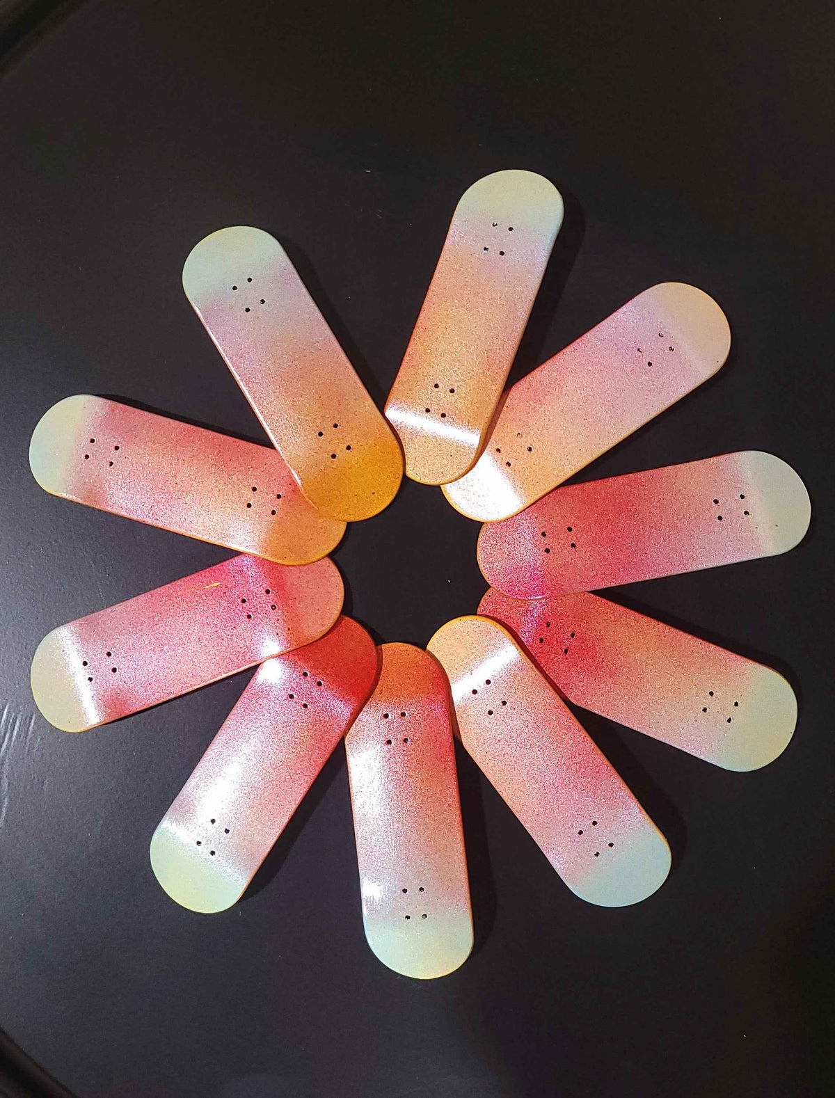 Collection of handmade custom fingerboard decks with colorful gradient designs.