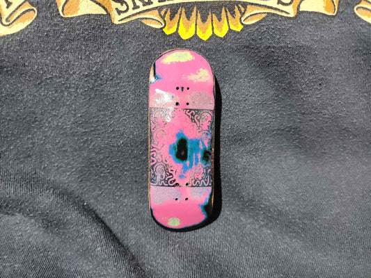 Custom handmade fingerboard deck with pink and blue psychedelic graphic design.