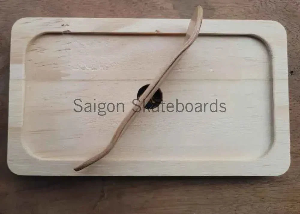 Handmade wooden fingerboard ramp with a matching wooden accessory on a light wood surface.