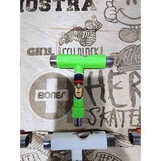 Neon green fingerboard trucks with custom graphic detail on a wooden surface.