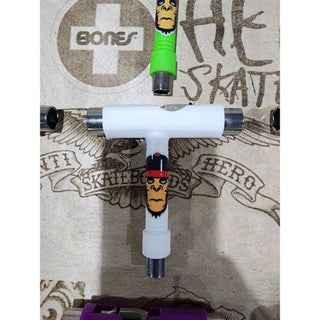 Custom fingerboard trucks with green wheels and graphic design on a wooden surface.