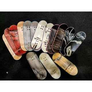 Collection of various handmade custom fingerboard decks with different wood grain patterns.