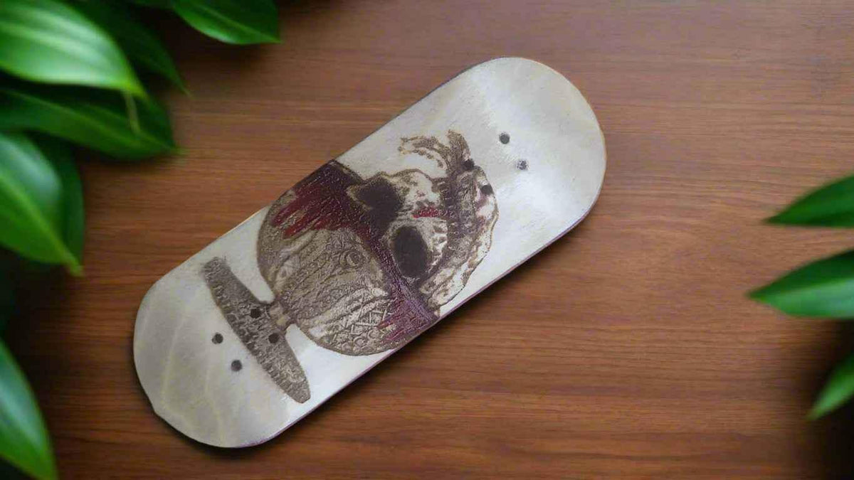 Handmade fingerboard deck with a skull graphic on a wooden surface