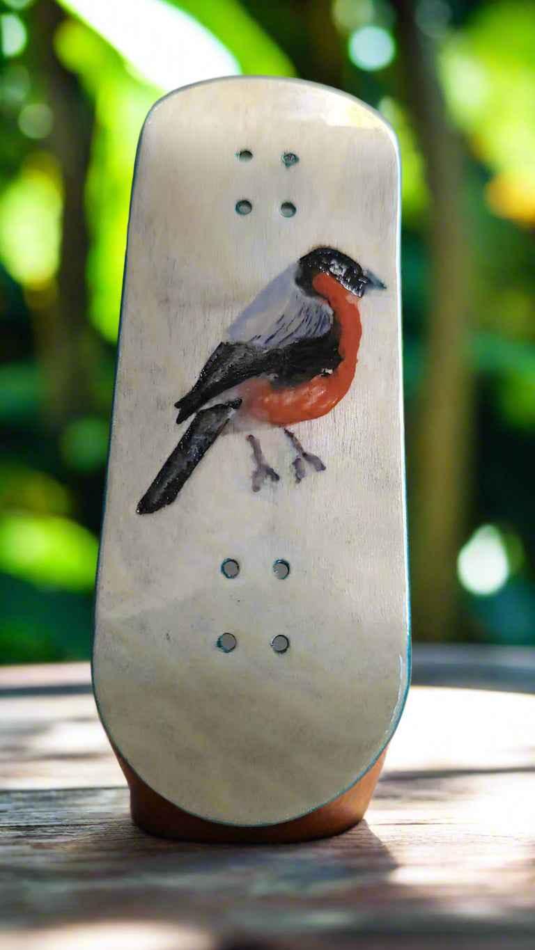 Handmade fingerboard deck featuring a bird illustration on a light wood surface