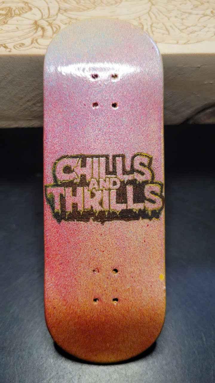 Custom fingerboard deck with a purple and orange gradient and 'Chills and Thrills' graphic