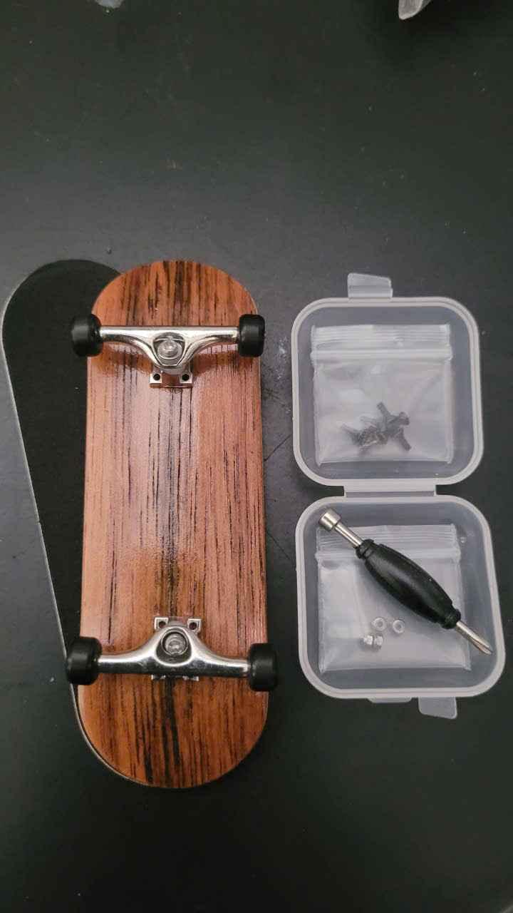Custom wood grain fingerboard deck with silver trucks, wheels, and assembly tools.